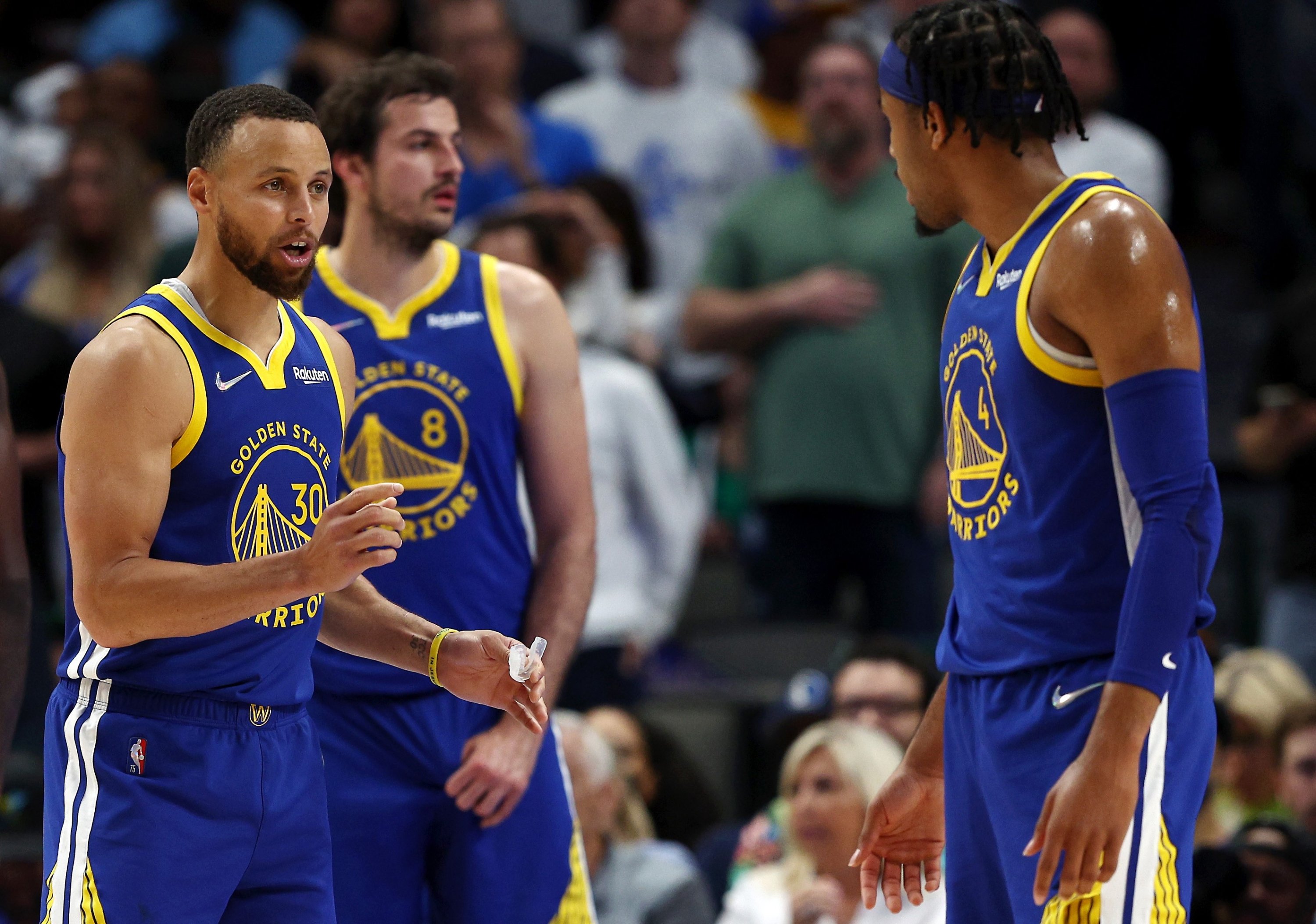 Stephen Curry dari Warriors (kiri) berbicara dengan rekan setimnya Moses Moody (kanan) selama Game 4 final Wilayah Barat NBA, Dallas, Texas, AS, 24 Mei 2022. (AFP Photo)