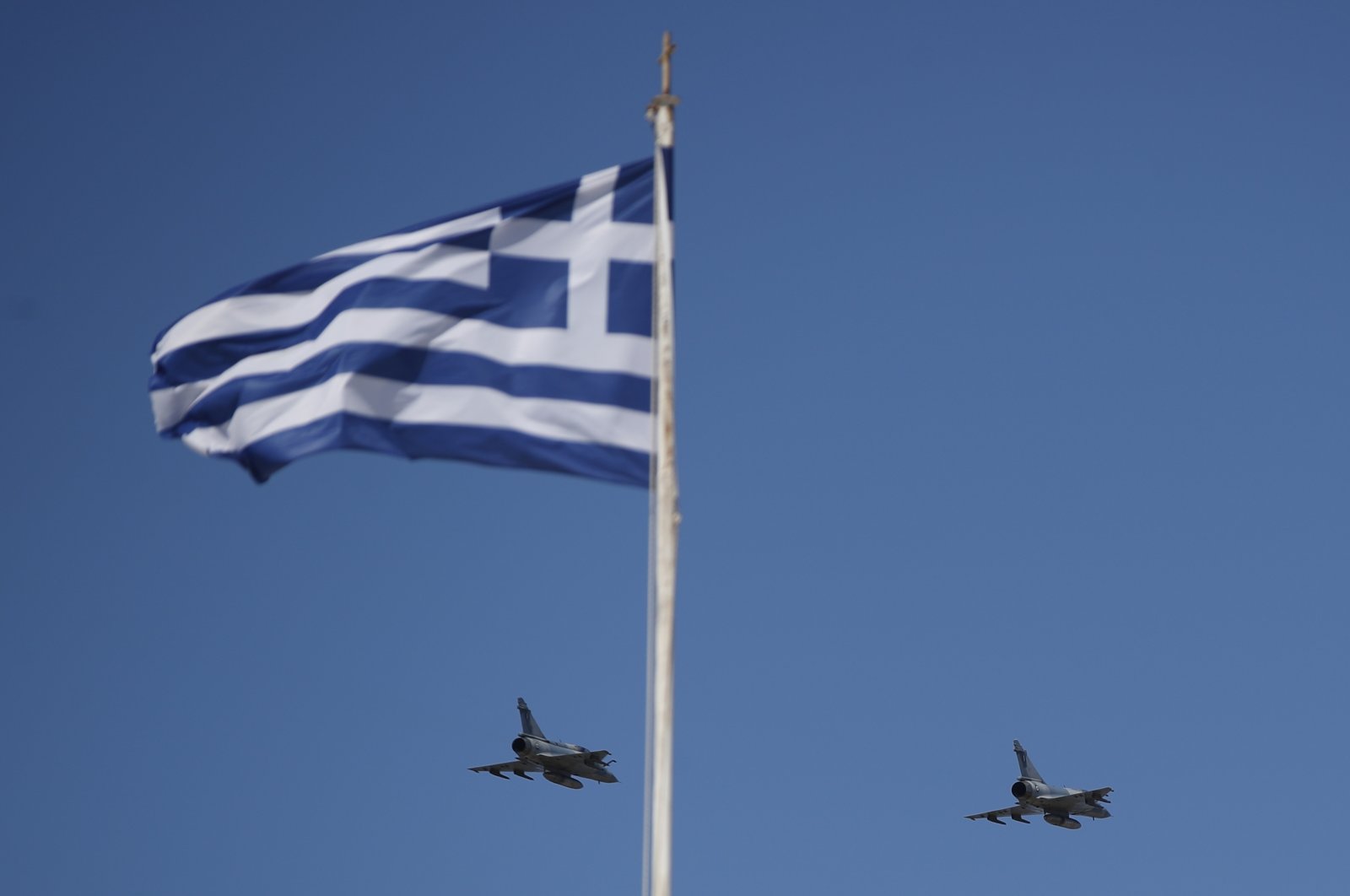 The Greek flag waves as two warplanes fly over the Holy Church of Panagia of Tinos on the Aegean island of Tinos, Greece, Aug. 15, 2020.  (AP File Photo)