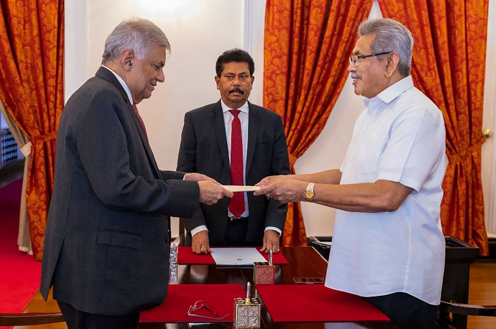 Sri Lanka&#039;s President Gotabaya Rajapaksa (R) swears in Prime Minister Ranil Wickremesinghe (L) as the new finance minister, in Colombo, Sri Lanka, May 25, 2022. (Sri Lanka&#039;s President&#039;s Office via AFP)