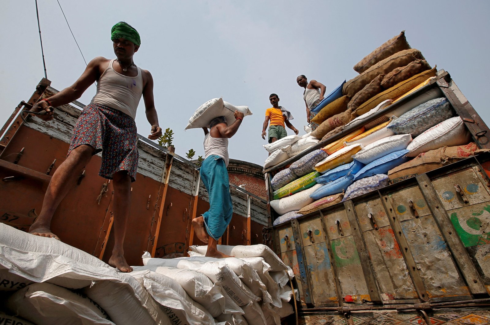 A laborer carries a sack filled with sugar to load it onto a supply truck at a wholesale market in Kolkata, India, Nov. 14, 2018. (Reuters Photo)