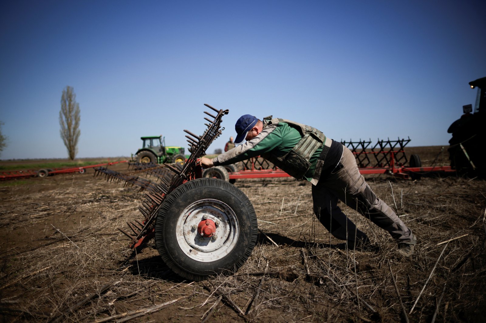 A Ukrainian farmer, wearing body armor, works in the topsoil in a field in the Zaporizhzhia region, Ukraine, April 26, 2022. (Reuters Photo)