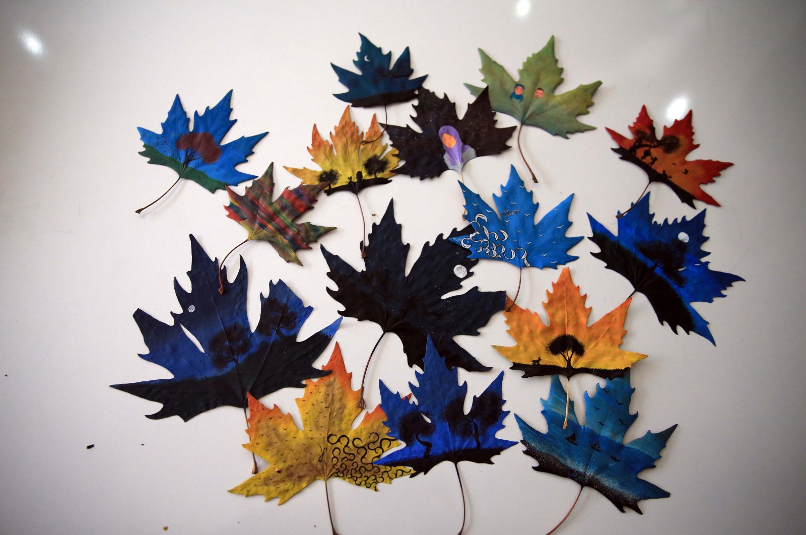 Kurir lokal mengubah daun pohon pesawat menjadi seni musim gugur