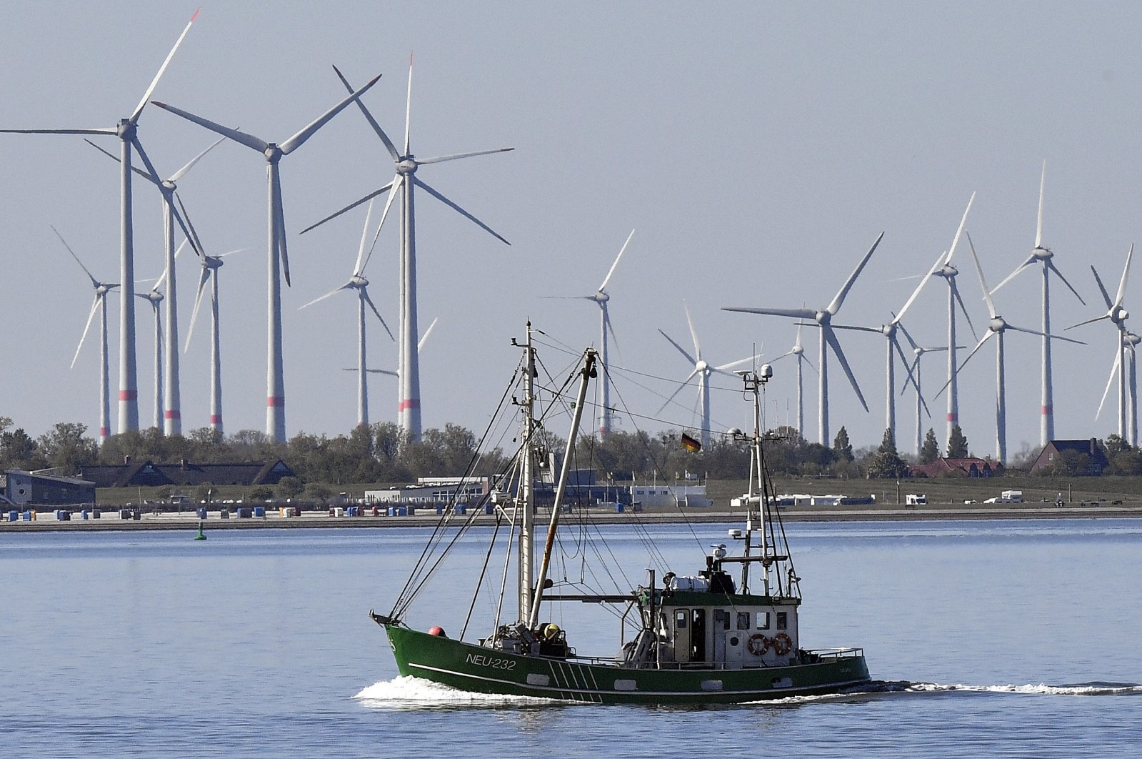 A fishing boat passes wind turbines between the Langeoog and Bensersiel islands on the North Sea coast in Germany, May 15, 2019. (AP Photo)
