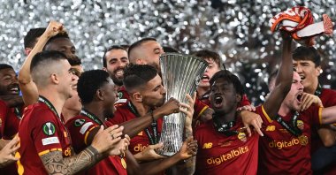 Roma's Italian midfielder and captain Lorenzo Pellegrini kisses the trophy as his teammates celebrate winning the UEFA Europa Conference League final against Feyenoord, Tirana, Albania, May 25, 2022. (AFP Photo)