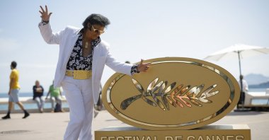 Elvis Presley impersonator Eryl Prayer poses on the Croisette near an installation of a  Palme d&#039;Or symbol ahead of the screening of the film &quot;Elvis&quot; Out of Competition, Cannes, France, May 25, 2022. (Reuters Photo)