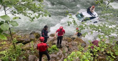 Rescue teams pass a rope to a couple stranded in a rushing river, in Rize, northern Turkey, May 25, 2022. (DHA PHOTO)
