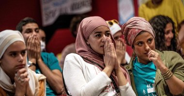 Members of the pro-burkini association Alliance Citoyenne watch the Municipal Council on a TV screen as members of the municipal council vote to allow or not the wearing of the burkini in the public swimming pools, Grenoble, France, May 16, 2022. (AFP Photo)