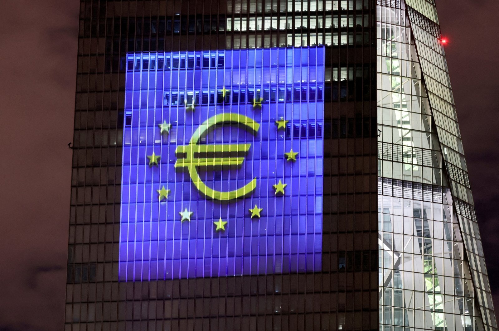 A symphony of light consisting of bars, lines and circles in blue and yellow, the colors of the European Union, illuminates the south facade of the European Central Bank (ECB) headquarters in Frankfurt, Germany, Dec. 30, 2021. (Reuters Photo)