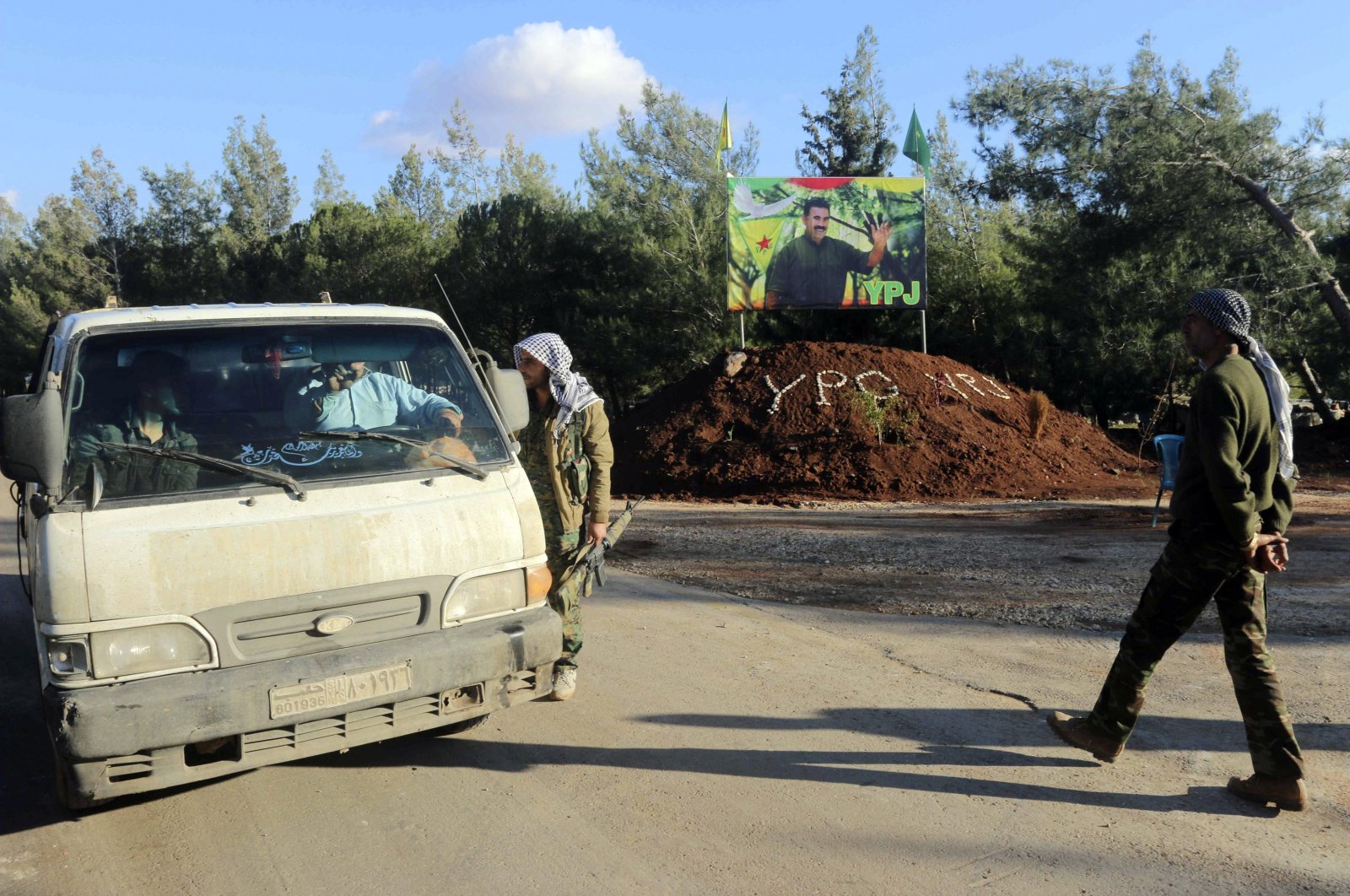 A picture of terrorist PKK&#039;s jailed leader Abdullah Öcalan is seen in the background as YPG/PKK terrorists man a checkpoint near the northern Syrian town of Afrin, Nov. 27, 2014. (Reuters File Photo)