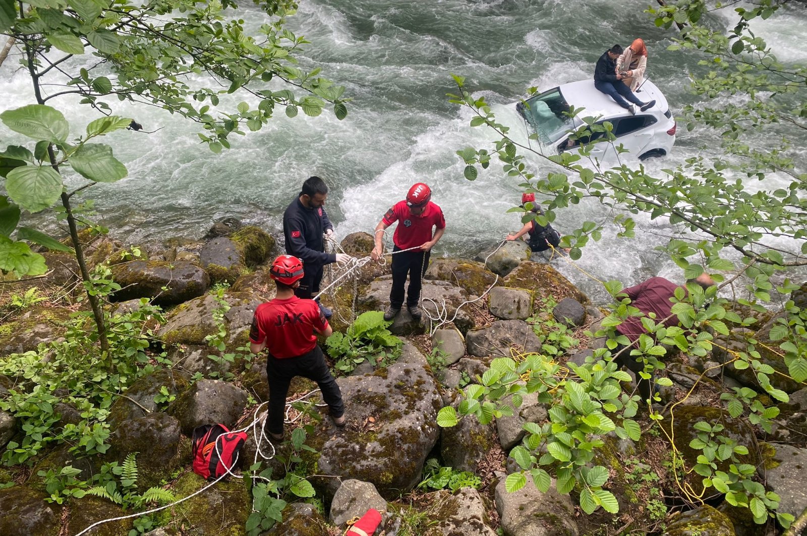 Rescue teams pass a rope to a couple stranded in a rushing river, in Rize, northern Turkey, May 25, 2022. (DHA PHOTO)