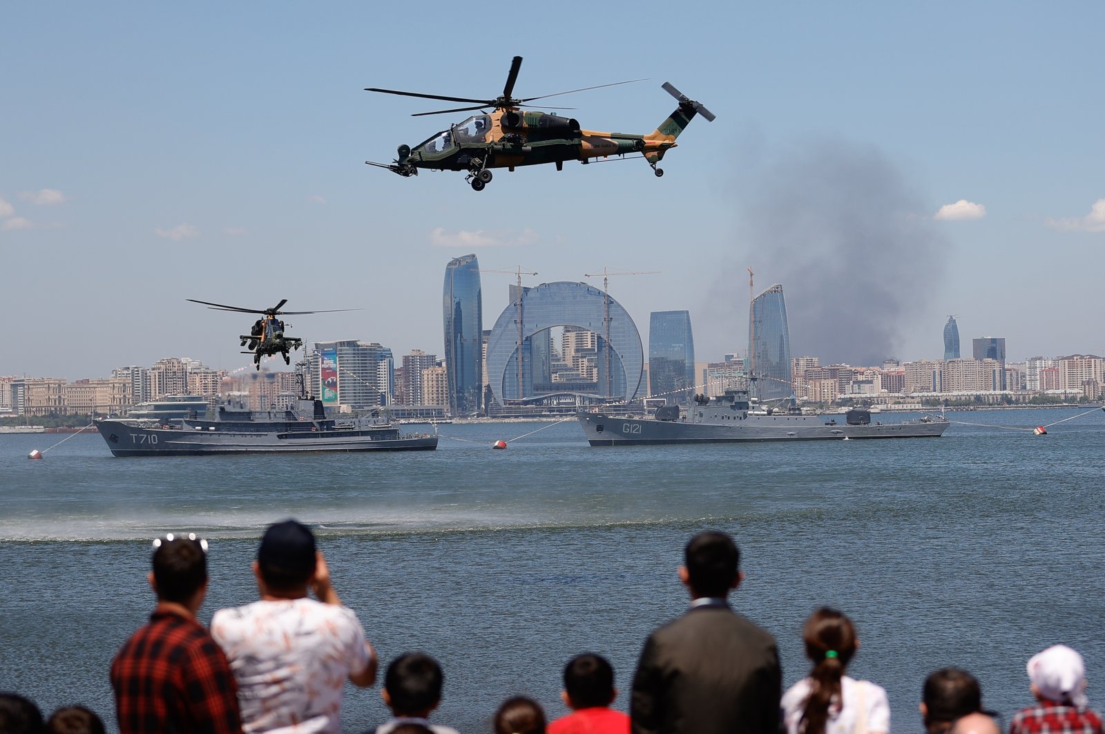 Two T129 Tactical Reconnaissance and Attack Helicopters (ATAK) (bottom) stage a show in Baku as part of Teknofest, Turkey’s largest aerospace and technology event, Azerbaijan, May 26, 2022. (AA Photo)