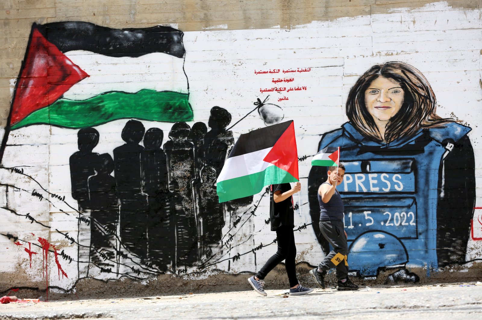 Palestinians walk in front of a mural for Al-Jazeera journalist Shireen Abu Akleh in the West Bank, Palestine, May 16, 2022. (EPA Photo)