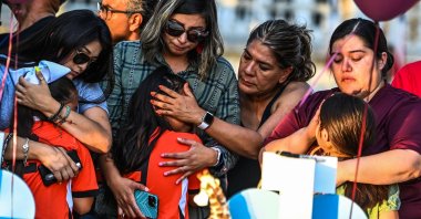Soccer teammates of Tess Mata, who died in Texas shooting, cry, supported by their mothers, as they visit a makeshift memorial outside the Uvalde County Courthouse in Texas, U.S., May 26, 2022. (AFP Photo)