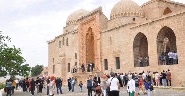 People are seen near a historic site in the southeastern province of Mardin, home to many civilizations throughout history, Turkey, May 4, 2022. (IHA Photo)