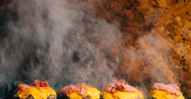 Four hamburgers are on the grill. (Sabah archive photo)