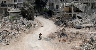 A man rides a motorbike past damaged buildings in the opposition-held town of Nairab, Idlib region, Syria, April 17, 2020. (Reuters Photo)