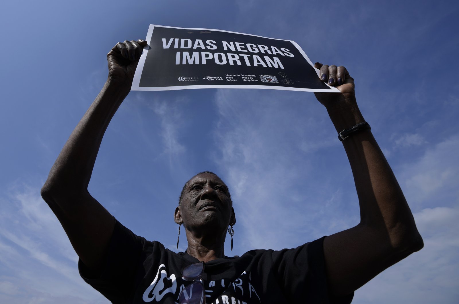 Zilda Maria de Paula, who said her 16-year-old son was killed during a police operation, holds a Portuguese "Black Lives Matter" poster during a protest demanding justice outside the Supreme Court in Brasilia, Brazil, May 12, 2022, (AP Photo)