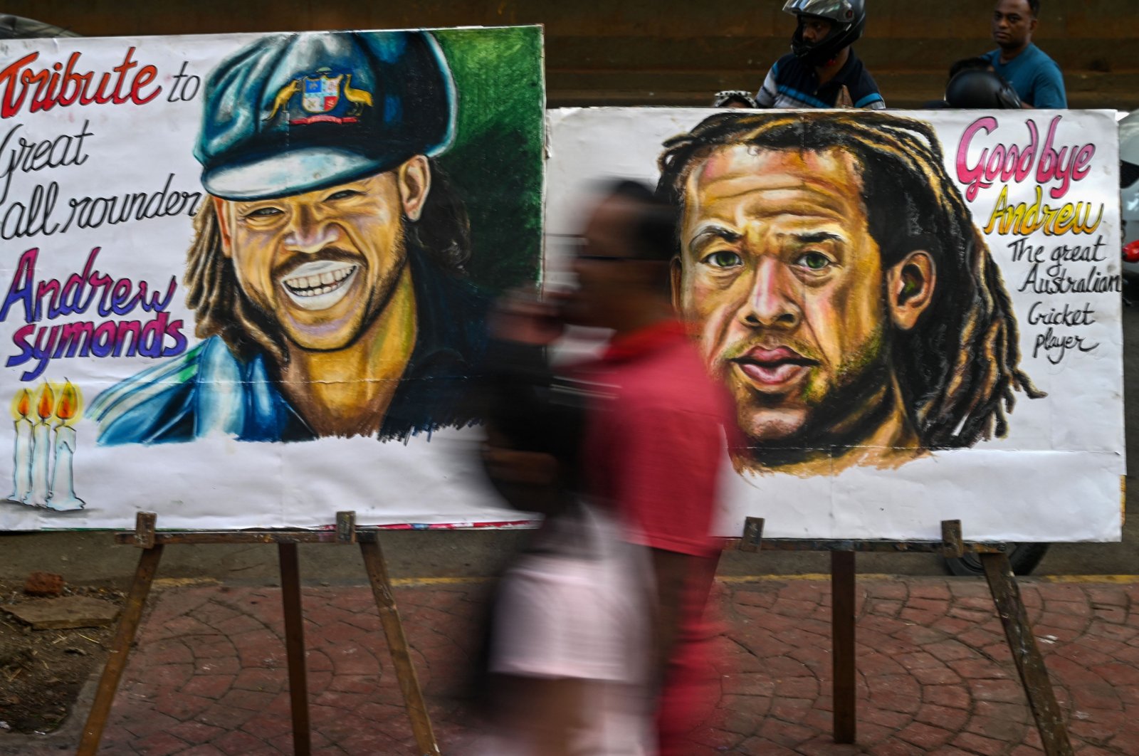 Pedestrians walk past paintings of late Australian cricketer Andrew Symonds, Mumbai, India, May 15, 2022. (AFP Photo)