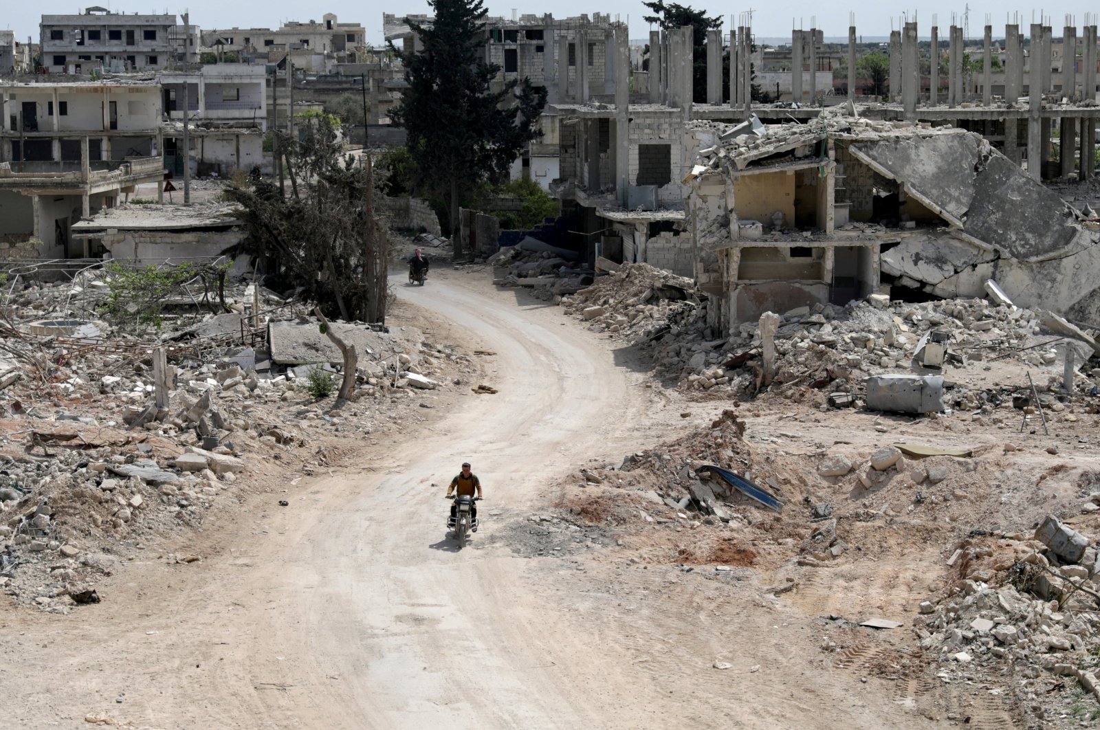 A man rides a motorbike past damaged buildings in the opposition-held town of Nairab, Idlib region, Syria, April 17, 2020. (Reuters Photo)