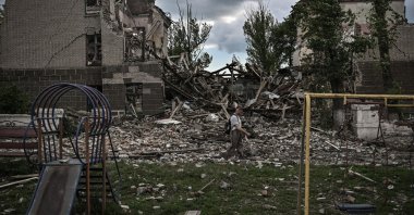 A man walks in front of a destroyed school in the city of Bakhmut amid the Russian invasion of Ukraine, Donbass region, eastern Ukraine, May 28, 2022. (AFP Photo)