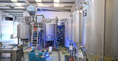 A worker goes down a ladder after checking a brewing vessel at Pressure Drop Brewery, in north London, U.K., May 21, 2022. (AFP Photo)