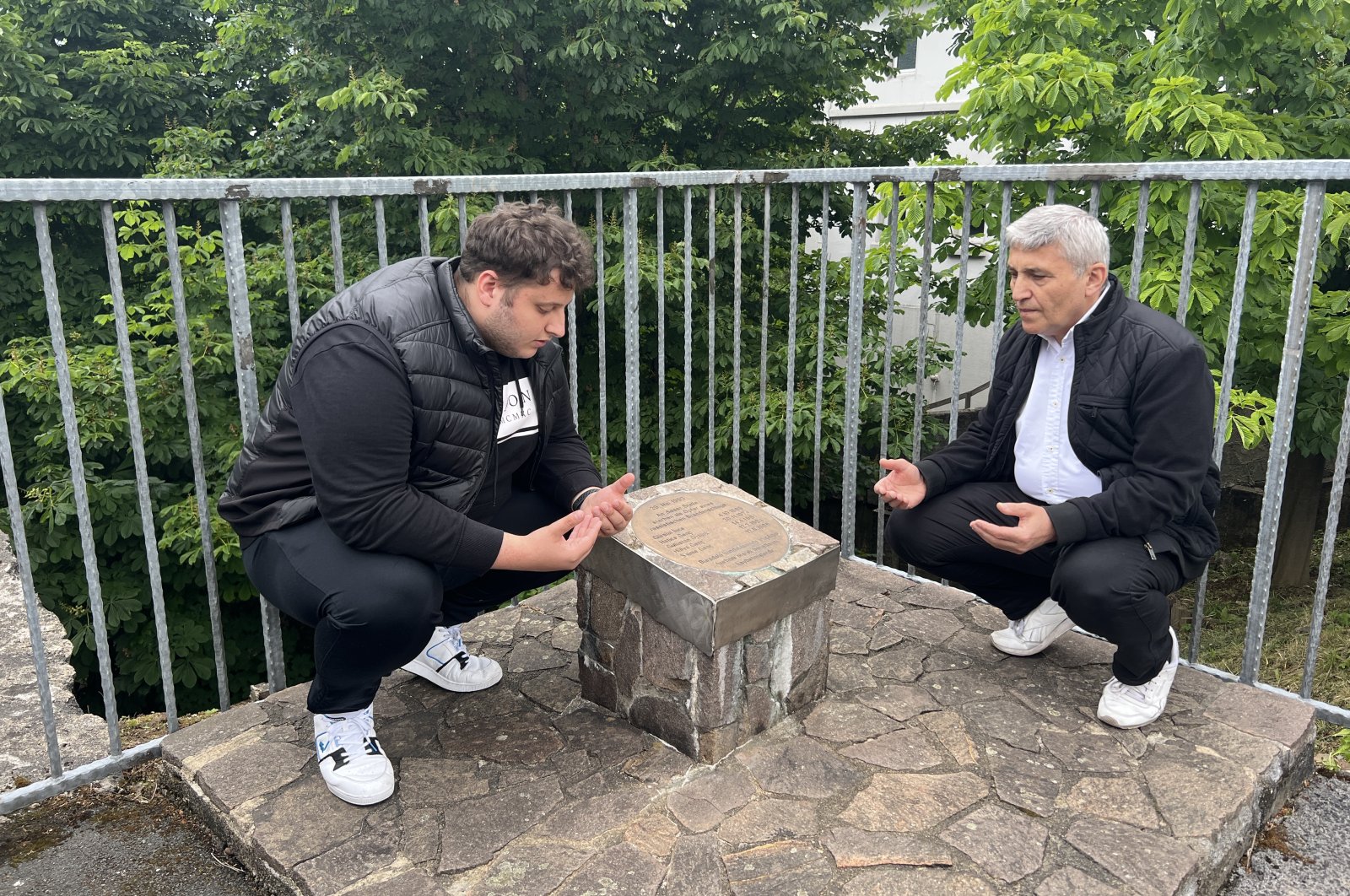 Kamil Genç (R) who lost his two daughters, two older sisters and niece in the racist attack on May 29, 1993, praying at a commemorative plaque dedicated to the victims, Solingen, Germany, May 29, 2022. (AA Photo)