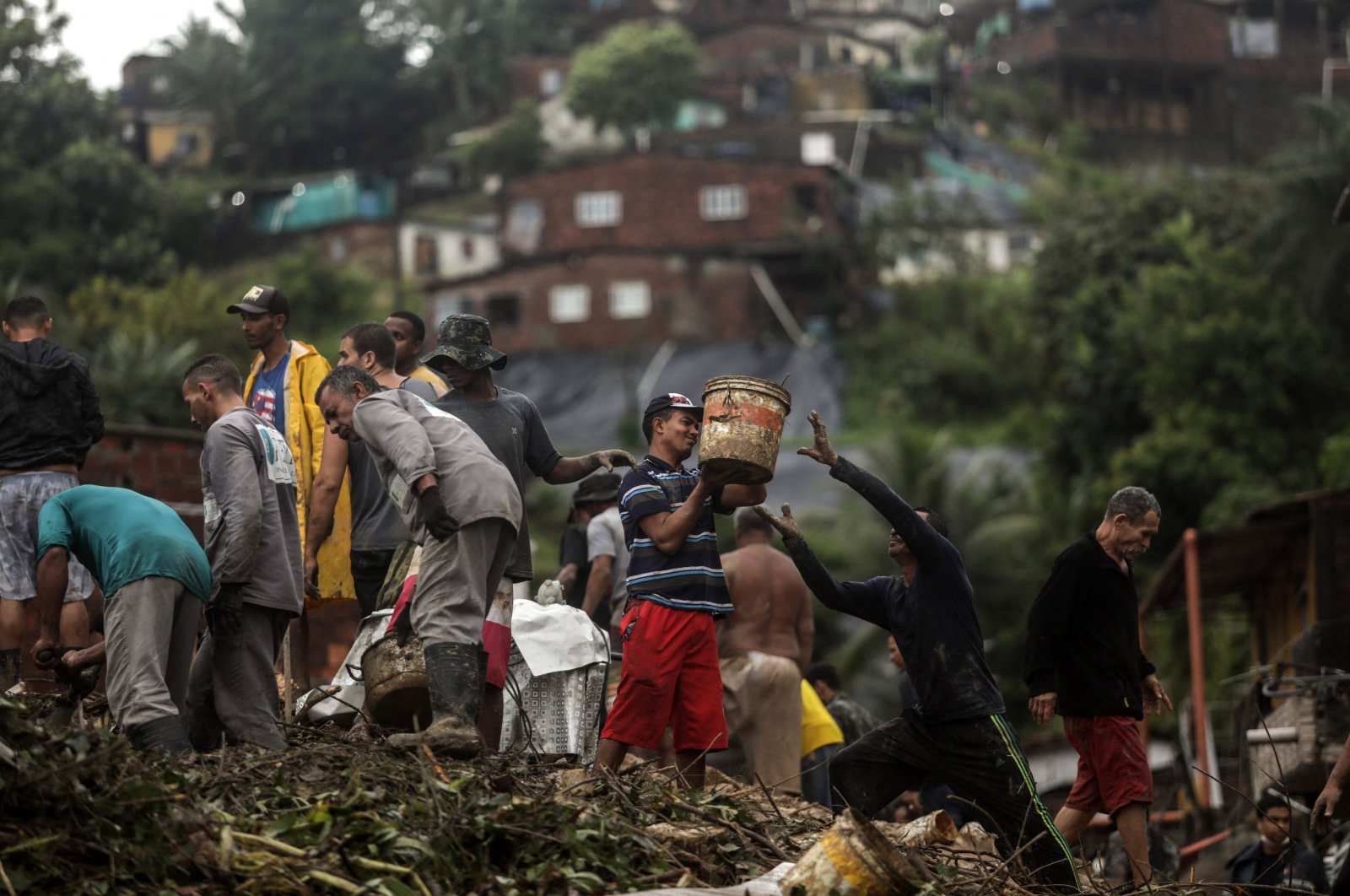 Residents and rescue workers remove debris during a rescue mission amid the debris left by a landslide in the community Jardim Monte Verde, Ibura neighborhood, in Recife, Pernambuco state, Brazil, May 28, 2022. (AFP Photo/Racife City Hall/Diego Nigro)