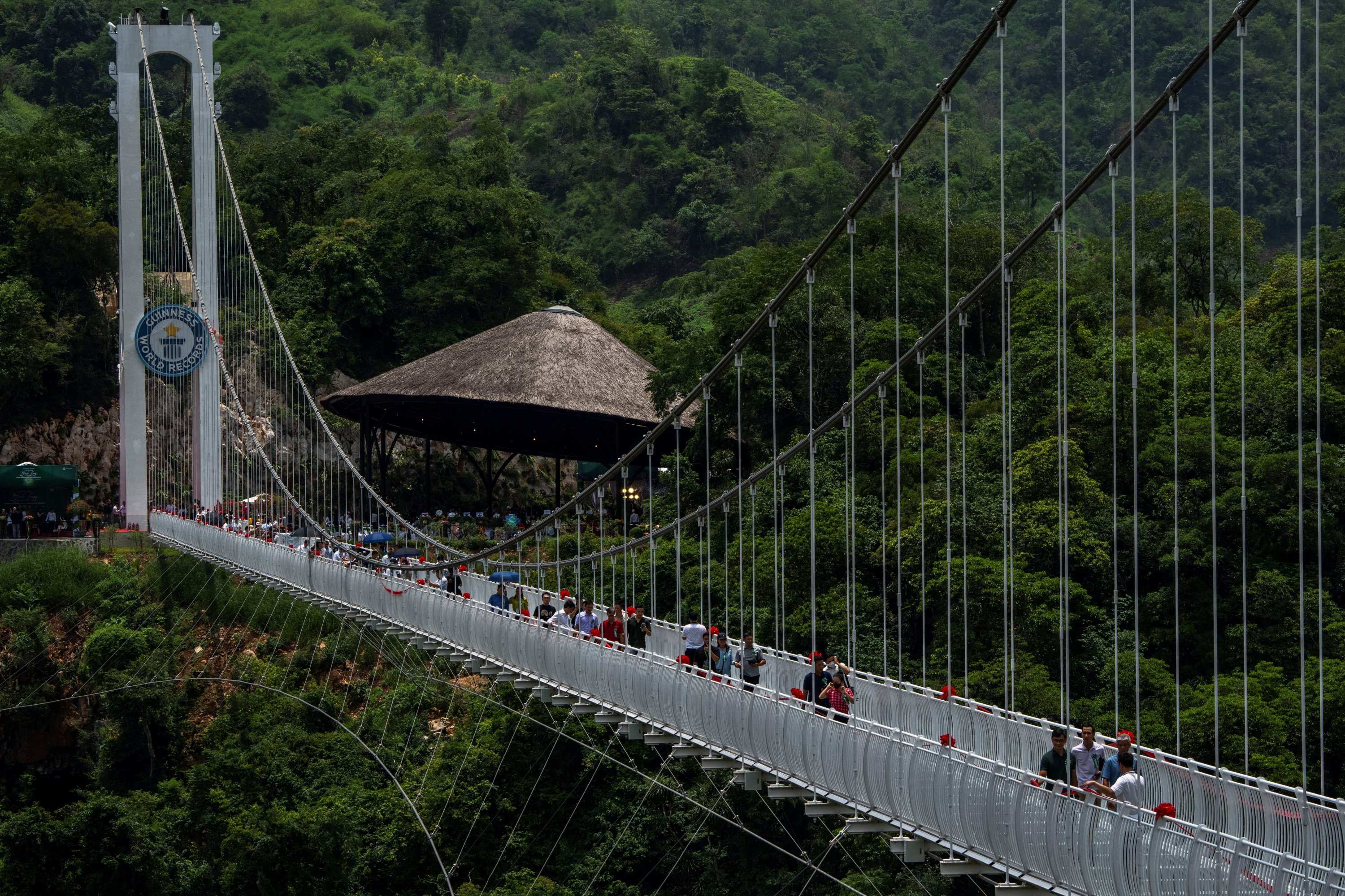 Orang-orang berjalan di jembatan kaca Bach Long selama upacara pembukaan di distrik Moc Chau di provinsi Son La, Vietnam, 28 Mei 2022. (Foto Reuters)