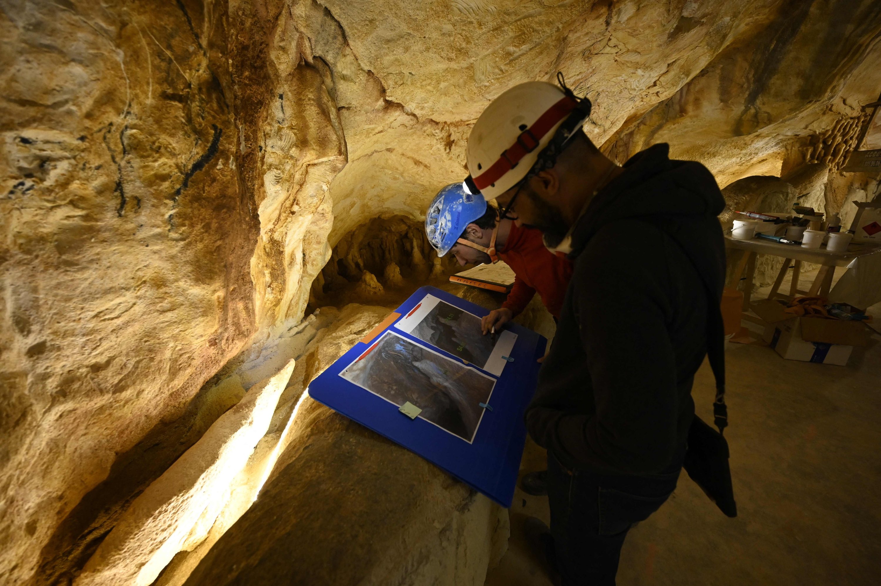Para pekerja melihat gambar di situs replika gua Cosquer di Villa Mediterranee di Marseille, Prancis selatan, 23 November 2021. (AFP Photo)