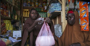 Halimo Hersi, 42, right, buys wheat flour from a shopkeeper in the Hamar-Weyne market in the capital Mogadishu, Somalia, May 26, 2022. (AP Photo)