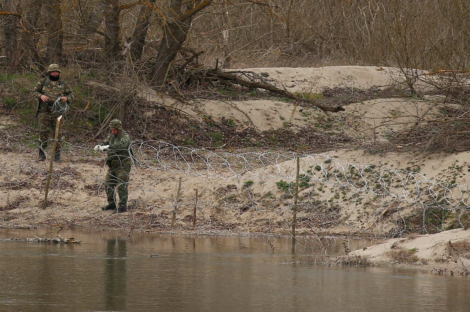 Greek soldiers set up a barbed wire by the Meriç (Maritsa) River as they are pictured from the Turkish village of Doyran, near Edirne, Turkey, March 10, 2020. (Reuters File Photo)