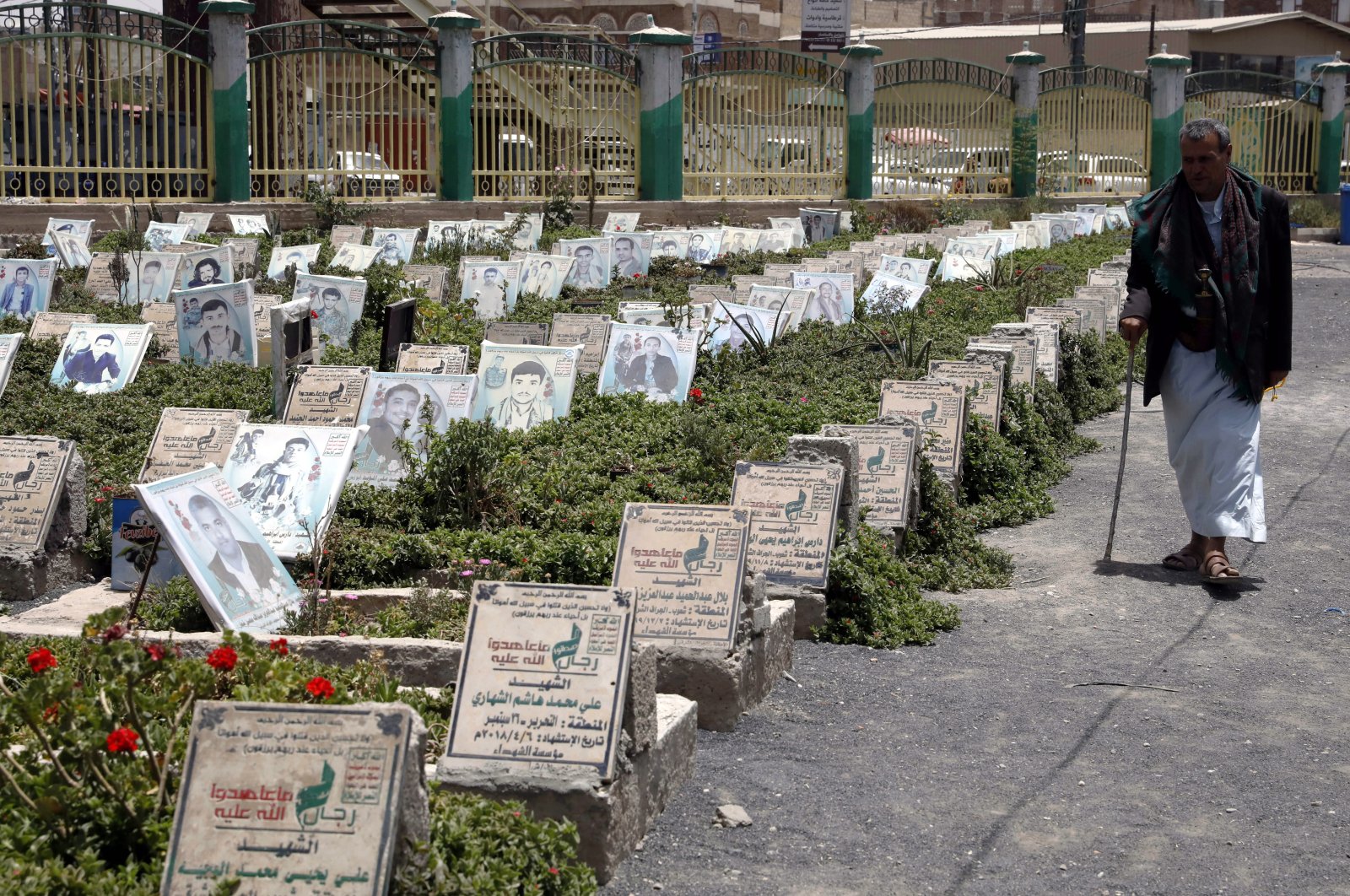A Yemeni passes portraits on the graves of those who were killed in Yemen’s current war at a cemetery in Sanaa, Yemen, May 28, 2022. (EPA Photo)