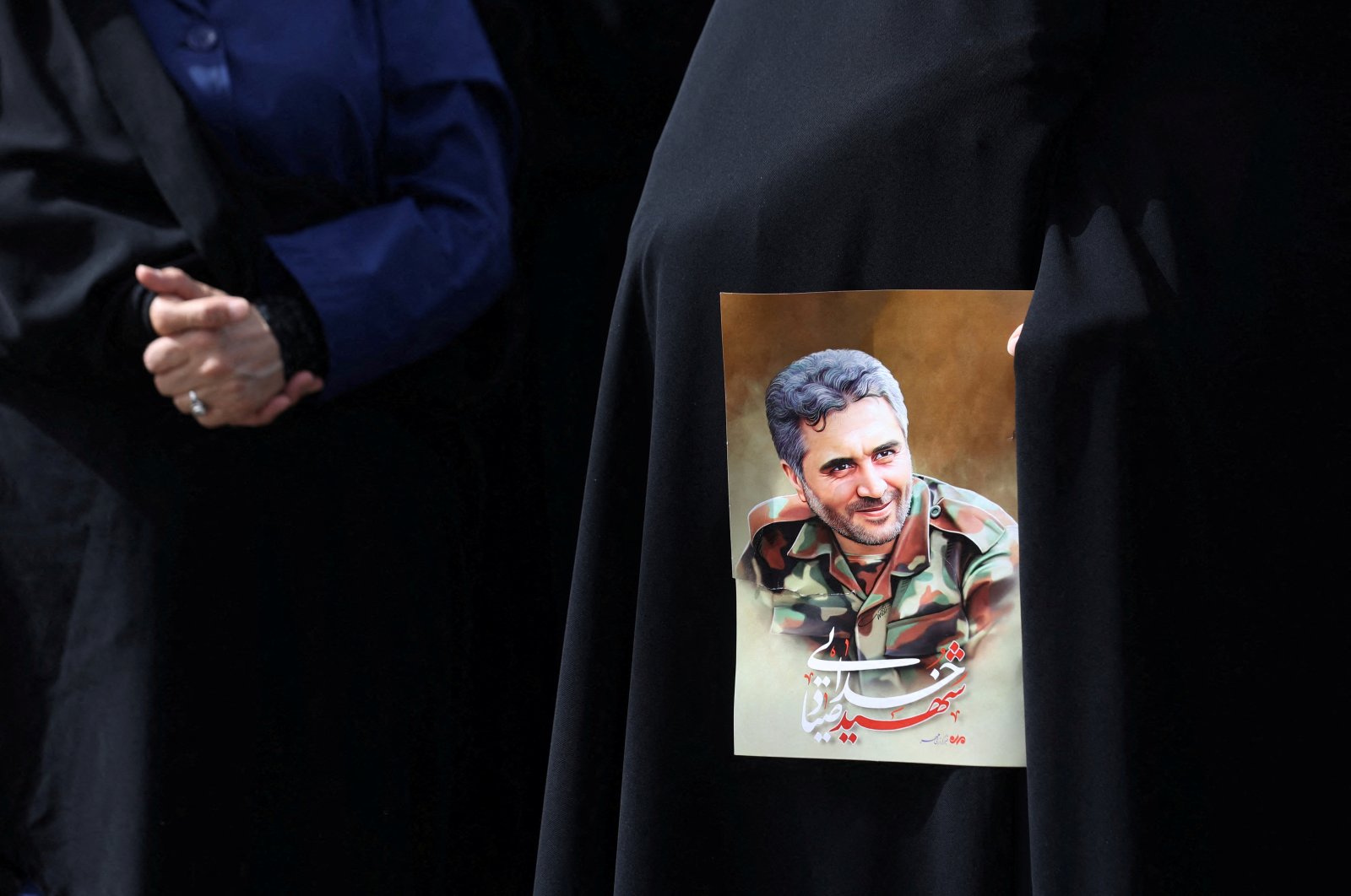 An Iranian woman holds a picture of Colonel Sayad Khodai, a member of Iran&#039;s Islamic Revolution Guards Corps in Tehran, Iran, May 24, 2022. (West Asia News Agency via Reuters)