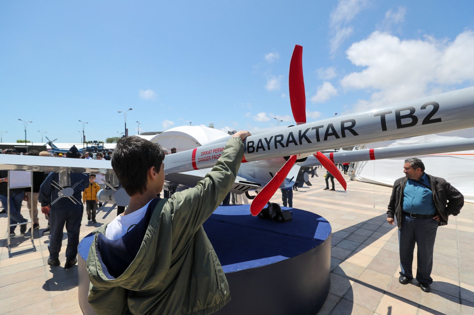A young man looks at a Bayraktar TB2 drone, manufactured by Turkey&#039;s Baykar, as it is presented during the opening of the aerospace and technology festival Teknofest Azerbaijan at Baku Crystal Hall in Baku, Azerbaijan, May 27, 2022. (AFP Photo)