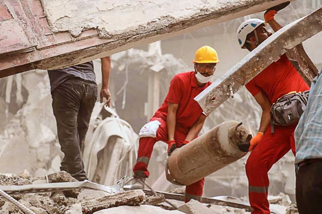 Red Crescent members work in the aftermath of the collapse of a 10-story building in Abadan, Khuzestan province, Iran, May 24, 2022. (Iranian Red Crescent Handout Photo via EPA)