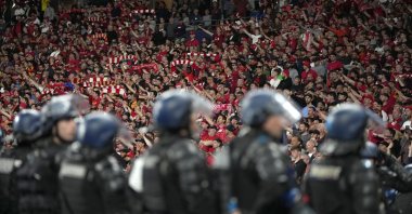 Riot police watch Liverpool fans during the Champions League final soccer match between Liverpool and Real Madrid at the Stade de France in Paris, France, May 28, 2022. (AP Photo)