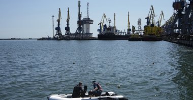Officials work to defuse a mine in an area of the Mariupol Sea Port in Mariupol, eastern Ukraine, April 29, 2022. (AP Photo)