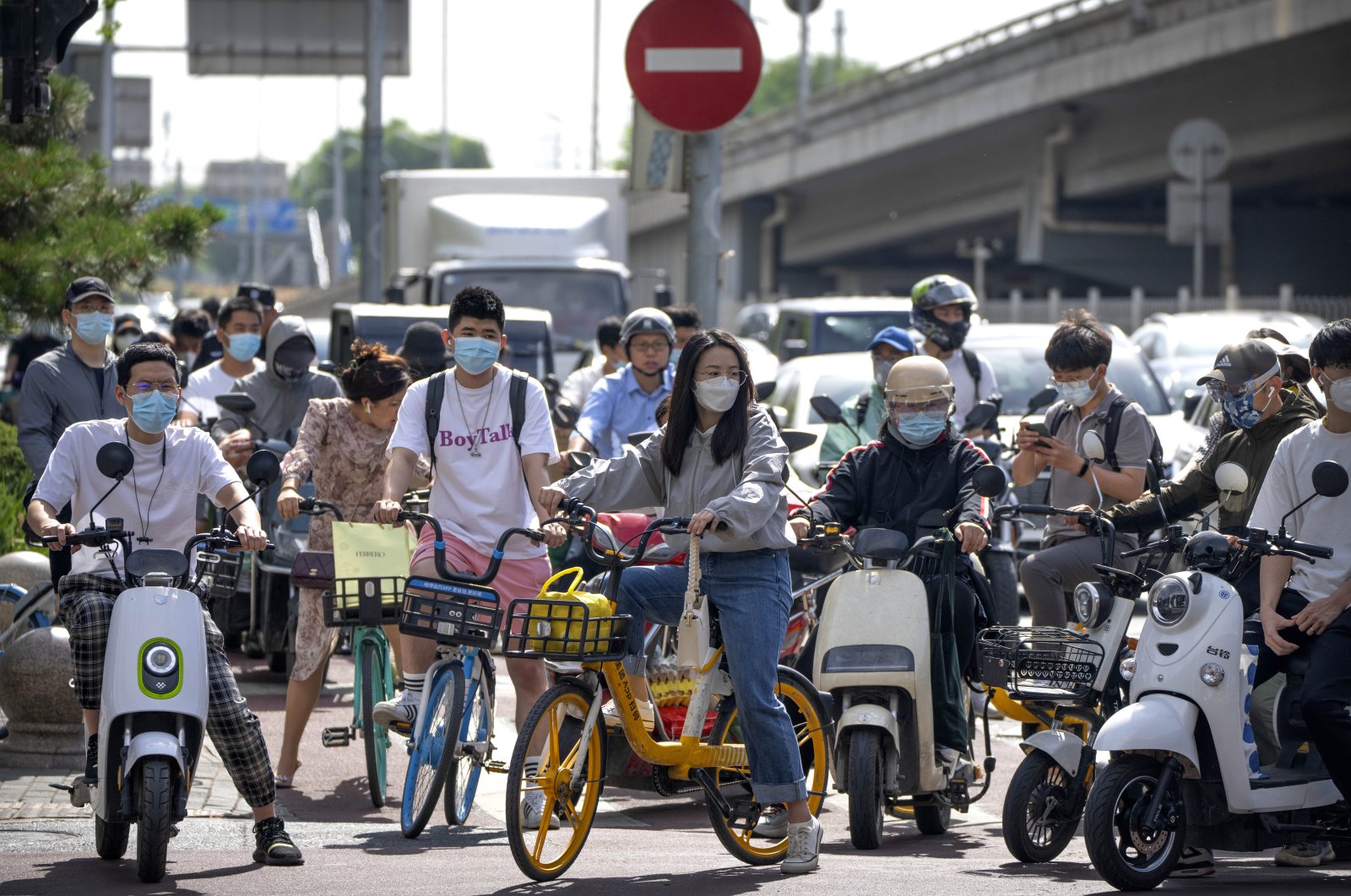 Commuters wearing face masks wait at an intersection in the central business district (CBD) in Beijing, China, May 31, 2022. (AP Photo)