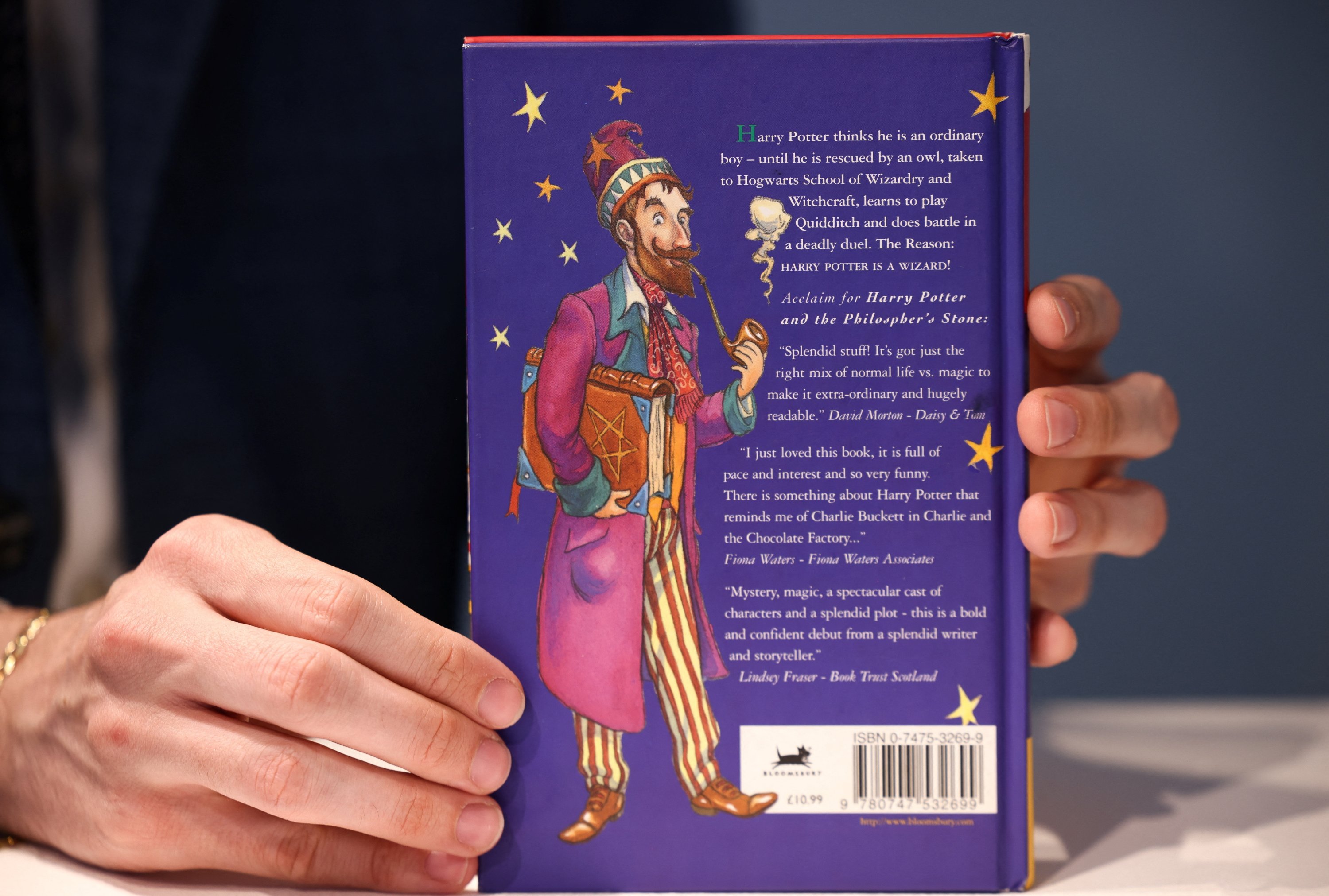 A person shows the back cover of a first edition of 