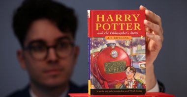 Rare books specialist and curator Mark Wiltshire poses with a rare first edition of "Harry Potter and the Philosophers Stone" signed by British author J.K. Rowling, which is to be put up for auction at Christie's auction house in London, U.K., May 31, 2022. (Reuters Photo)