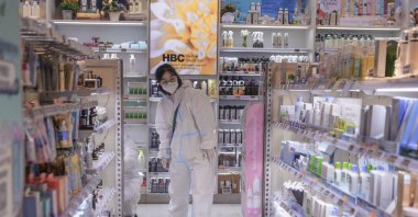 A woman in a protective suit stands in a grocery store amid the COVID-19 lockdown in Shanghai, China, May 26, 2022. (EPA Photo)