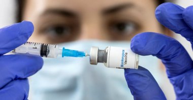 A woman holds a mock-up vial labeled &quot;Monkeypox vaccine&quot; and a medical syringe in this illustration created May 25, 2022. (Reuters Photo)