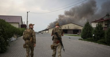 Ukrainian troops walk as seeds burn in a grain silo after it was shelled repeatedly, Donetsk region, Ukraine, May 31, 2022. (Reuters Photo)