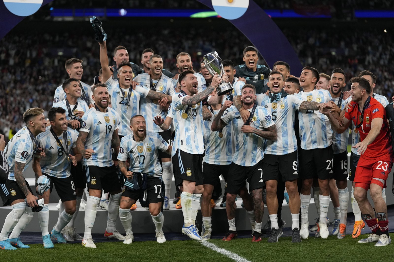 Argentina&#039;s Lionel Messi holds a trophy as he celebrates with his teammates after winning the Finalissima soccer match between Italy and Argentina at Wembley Stadium in London , Wednesday, June 1, 2022. (AP Photo)