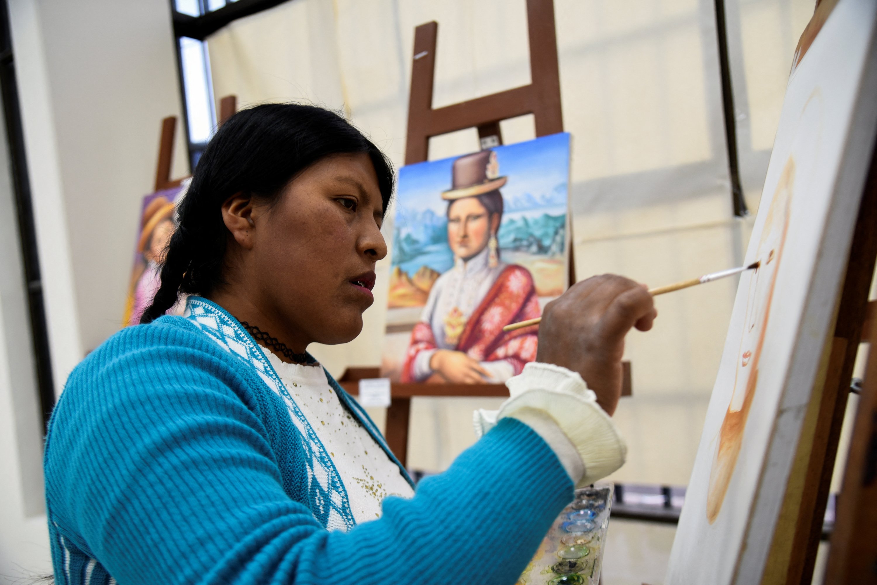 Claudia Callizaya, 32, seorang pelukis Bolivia yang dikenal sebagai Claudina, mengerjakan lukisan Mona Lisa bergaya cholita, di Universitas Umum El Alto, El Alto, Bolivia 21 Mei 2022. (Foto Reuters)