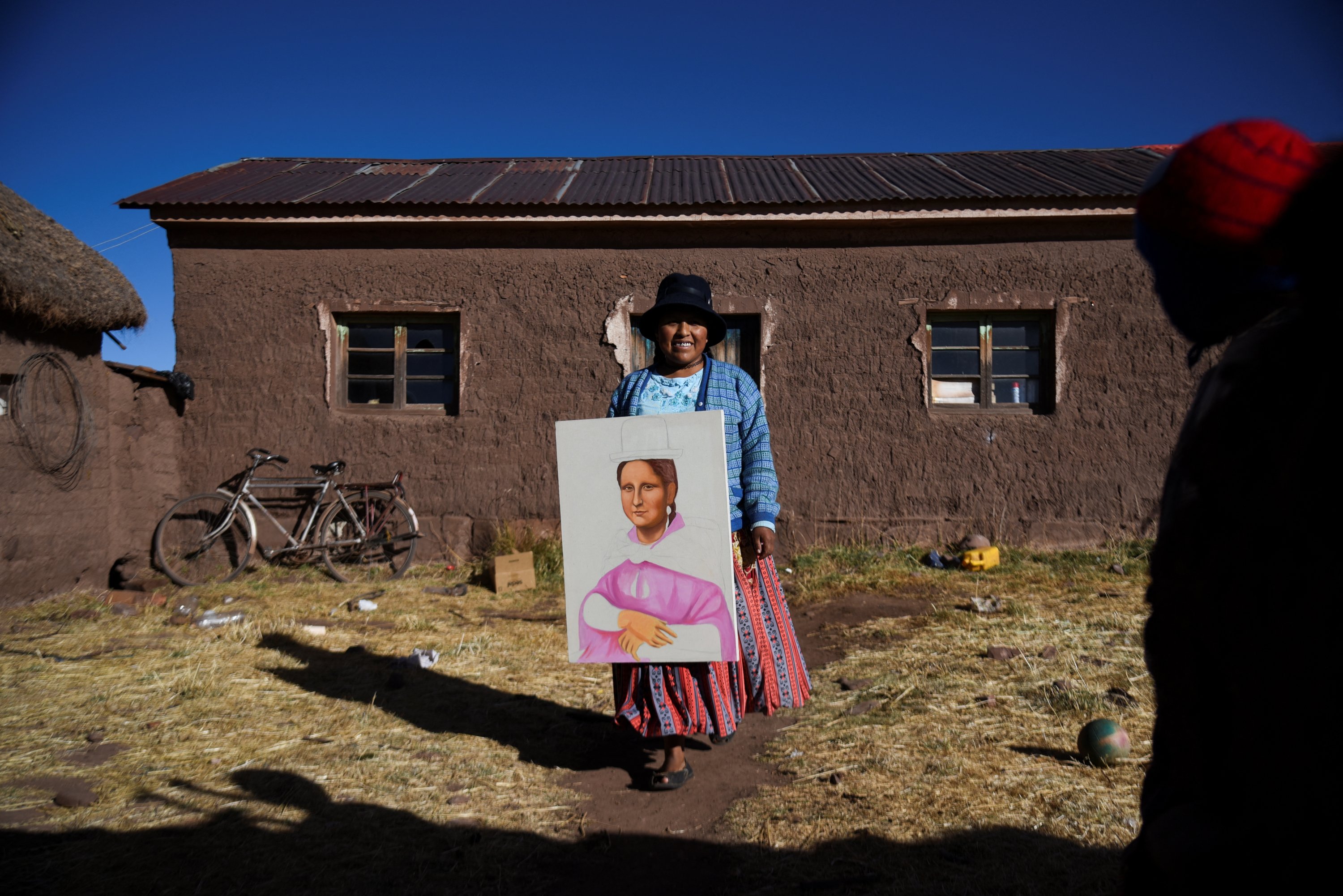 Claudia Callizaya, 32, seorang pelukis Bolivia yang dikenal sebagai Claudina, membawa lukisan Mona Lisa bergaya cholita, di rumahnya di Kalla Baja, Bolivia, 29 Mei 2022. (Foto Reuters)