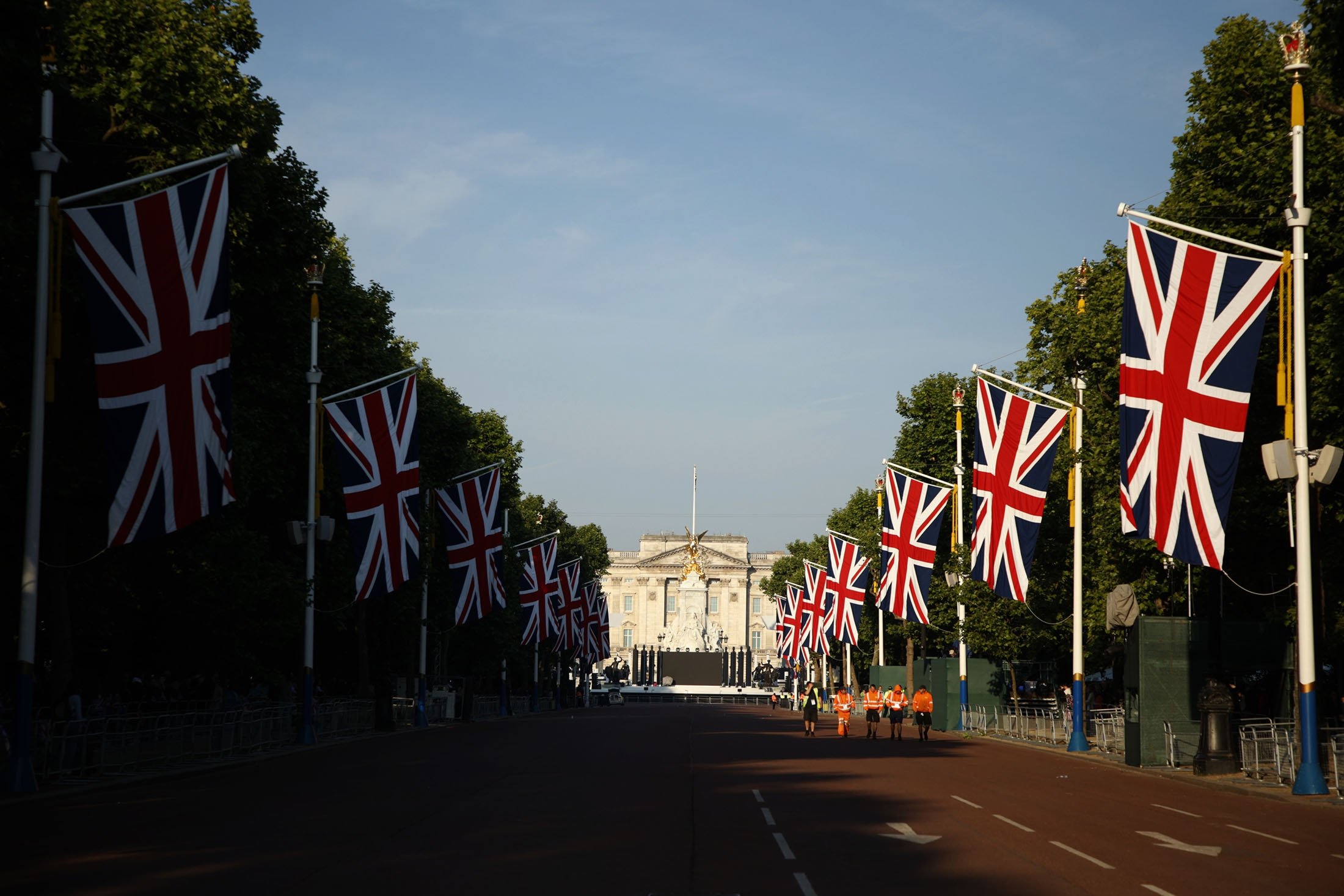 Sejumlah pekerja berjalan menyusuri Mall menuju Istana Buckingham pada hari pertama dari empat hari perayaan untuk menandai Platinum Jubilee, di London, Inggris, 2 Juni 2022. (AP Photo)