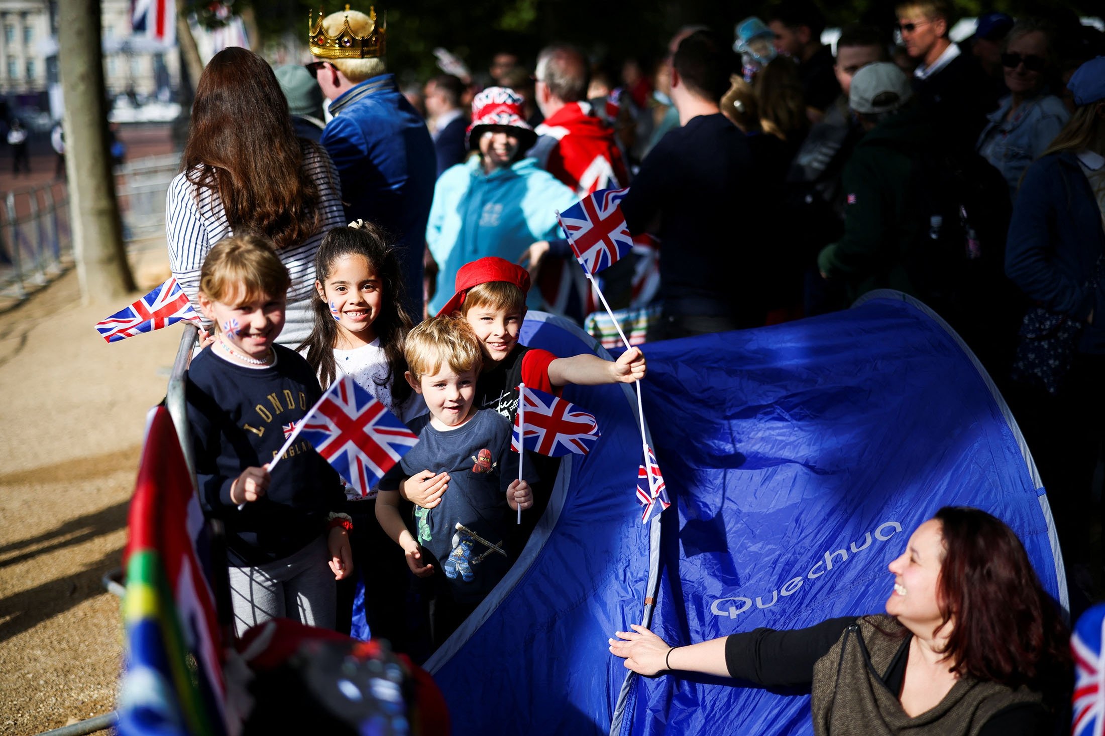 Anak-anak memegang bendera Union Jack berpose untuk foto saat mereka menghadiri perayaan Queen's Platinum Jubilee di Mall di London, Inggris, 2 Juni 2022. (Foto Reuters)