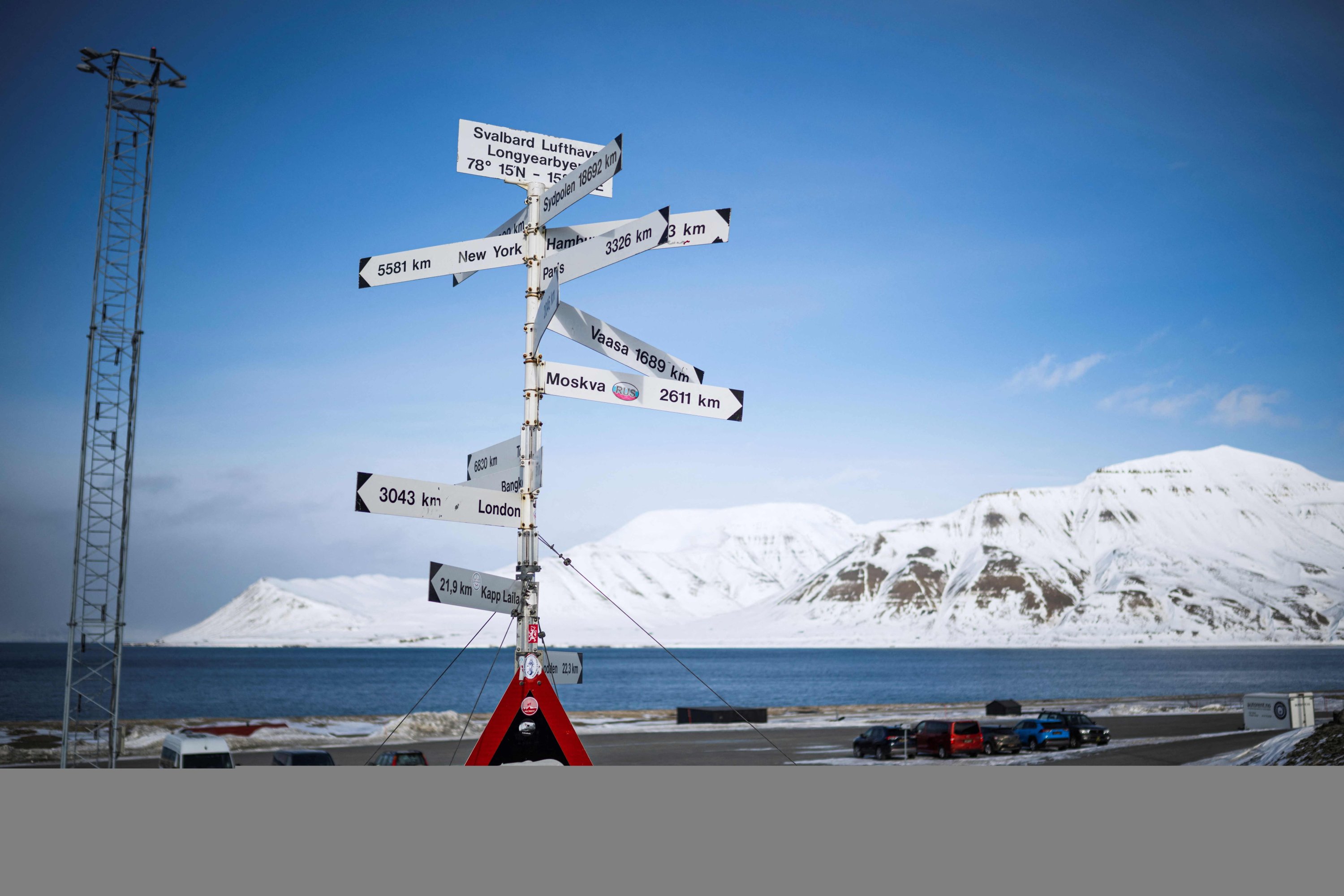File foto ini menunjukkan tanda peringatan yang menggambarkan beruang kutub dan jarak ke berbagai kota di seluruh dunia di sisi jalan di luar bandara Longyearbyen, Kepulauan Svalbard, Norwegia utara, 7 Mei 2022. (AFP Photo)
