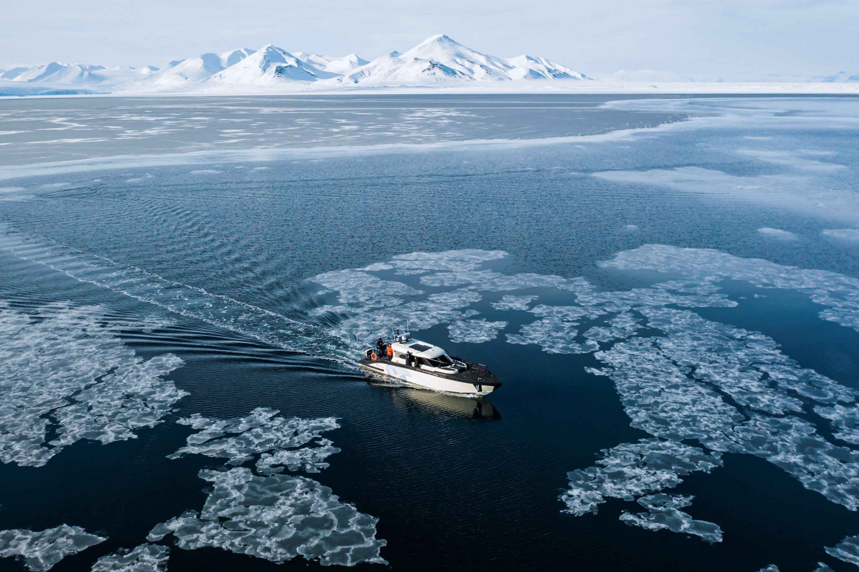 Gambar pandangan udara ini menunjukkan Kvitbjorn (Beruang Kutub, dalam bahasa Norwegia), sebuah perahu wisata hibrida, yang menggabungkan motor diesel dan baterai listrik, saat berlayar di es laut di Teluk Borebukta, yang terletak di sisi barat laut Isfjorden, di Kepulauan Svalbard, Norwegia utara, 3 Mei 2022. (AFP Photo)
